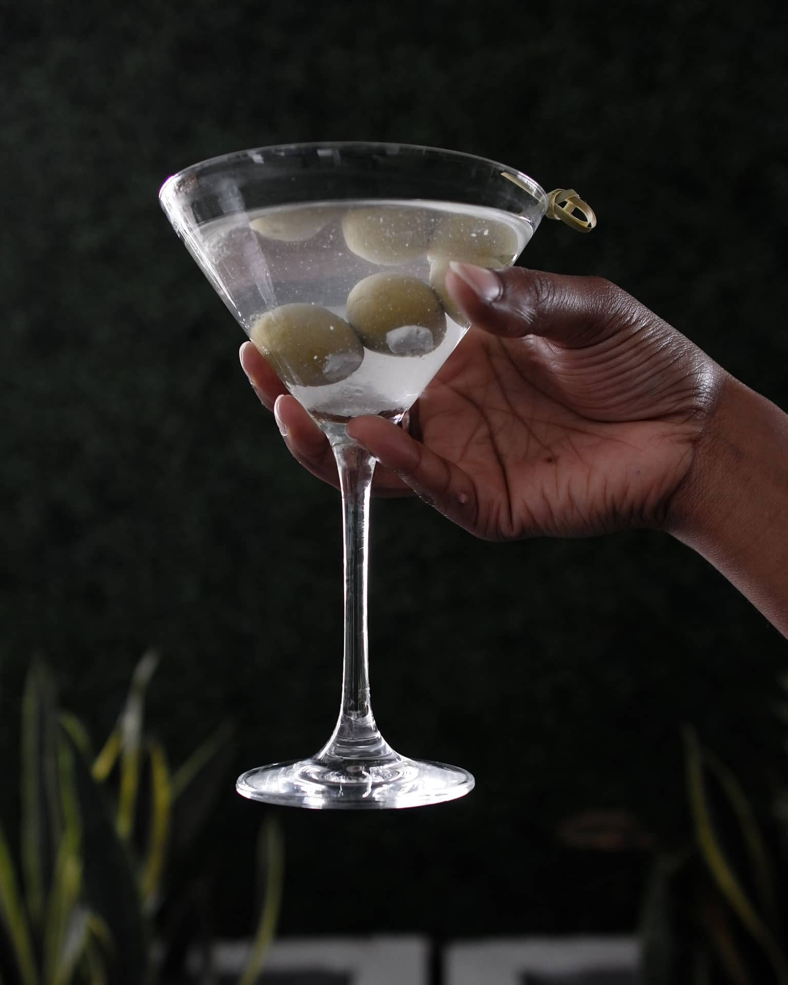Hand holding Classic Martini with stuffed olives